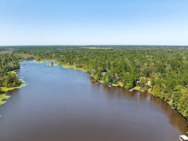 an aerial view of a house with a yard and lake view