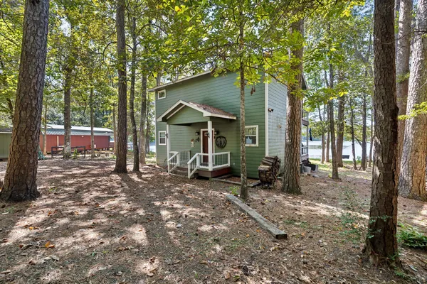 a view of a house with a tree in the forest