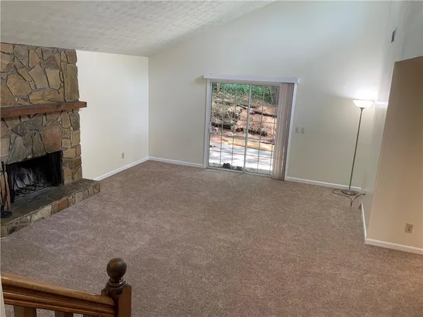 a view of an empty room with a fireplace and a window
