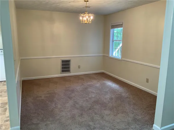 an empty room with windows and chandelier