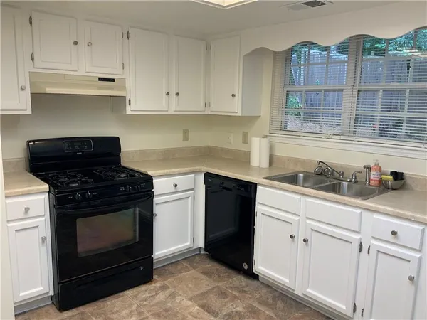 a kitchen with cabinets appliances and a sink