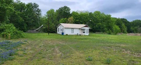 a white house that has a big yard with wooden fence