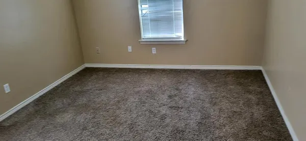 a view of a small space with wooden floor and a window