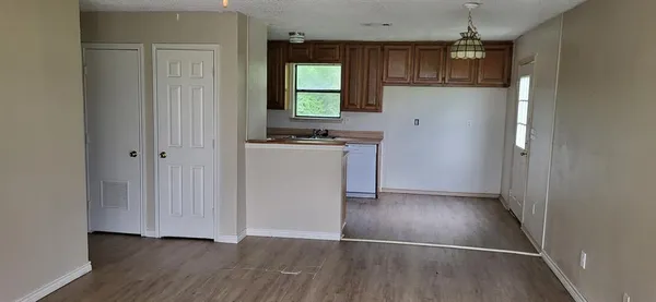 an empty room with wooden floor and a window