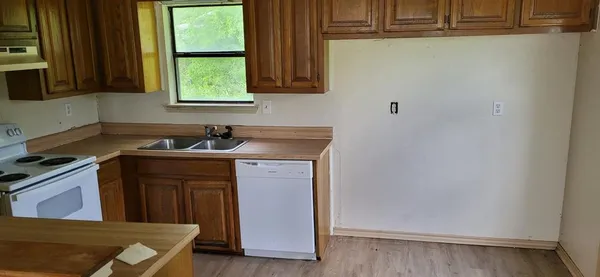 a kitchen with a sink a window and cabinets