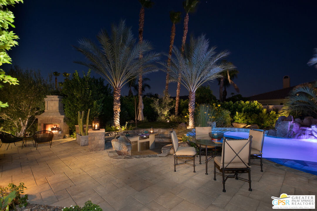 a view of a patio with a table and chairs and potted plants