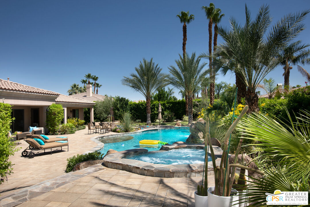 49880 Rancho San Felipe La Quinta, CA 92253 - Photo 37 of 47 a view of a swimming pool with a table and chairs under palm trees