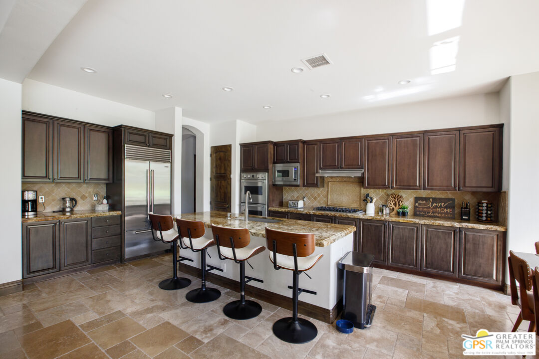 49880 Rancho San Felipe La Quinta, CA 92253 - Photo 9 of 47 a kitchen with stainless steel appliances kitchen island granite countertop a sink and cabinets