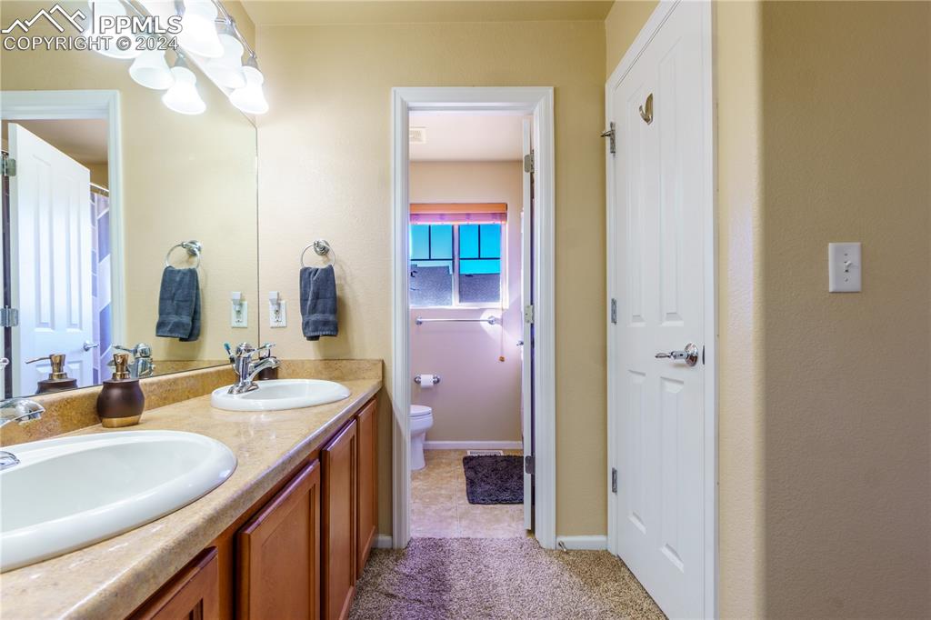 7332 Sandy Springs Point Fountain, CO 80817 - Photo 15 of 28 a bathroom with a double vanity sink and a mirror