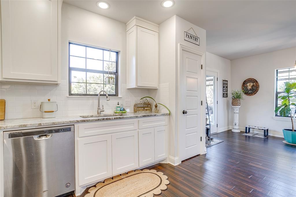 4920 Shining Star Trail Rio Vista, TX 76093 - Photo 20 of 40 a kitchen with granite countertop a sink cabinets stainless steel appliances and a window