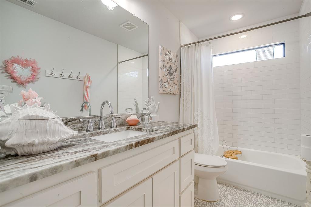 4920 Shining Star Trail Rio Vista, TX 76093 - Photo 25 of 40 a bathroom with a granite countertop sink mirror vanity and toilet
