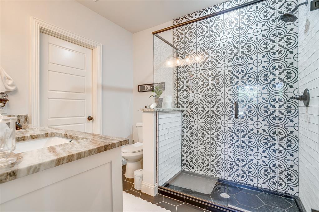 4920 Shining Star Trail Rio Vista, TX 76093 - Photo 30 of 40 a bathroom with a granite countertop sink a mirror and shower