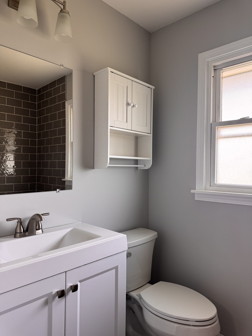 336 Lilac Lane, Unit H Elgin, IL 60123 - Photo 6 of 16 a bathroom with a sink vanity mirror and toilet