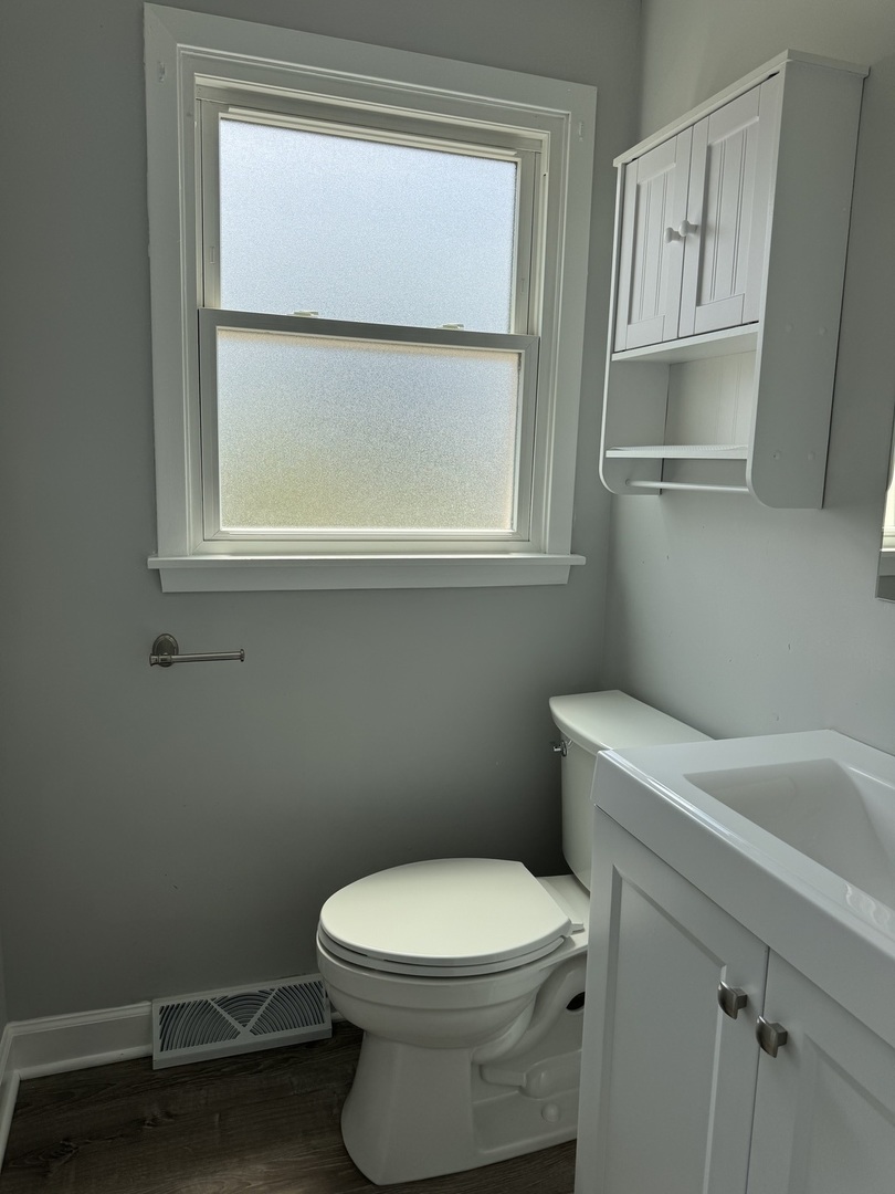 336 Lilac Lane, Unit H Elgin, IL 60123 - Photo 10 of 16 a bathroom with a toilet a sink and a window