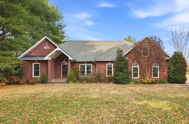 a front view of house with yard and trees around