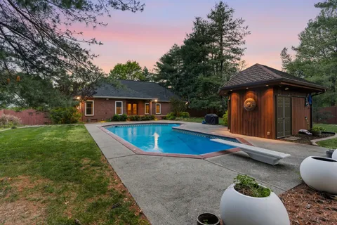 a view of house with swimming pool outdoor seating area