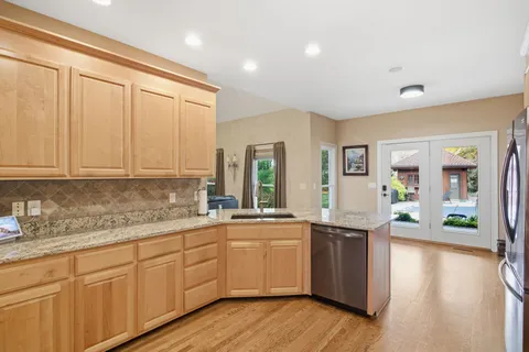 a kitchen with stainless steel appliances a sink cabinets and wooden floor