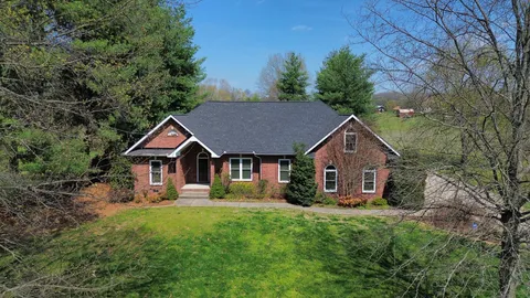 an aerial view of house with yard and trees in the background