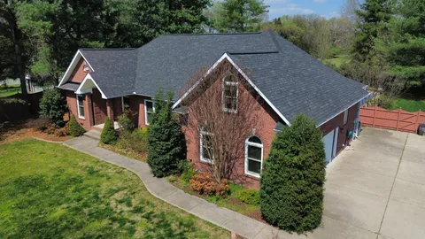 an aerial view of a house with a yard and lake view