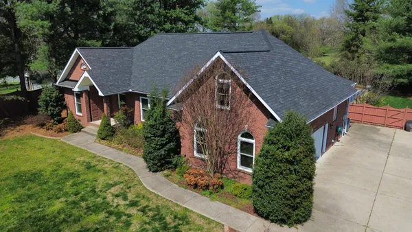 an aerial view of a house with a yard and lake view