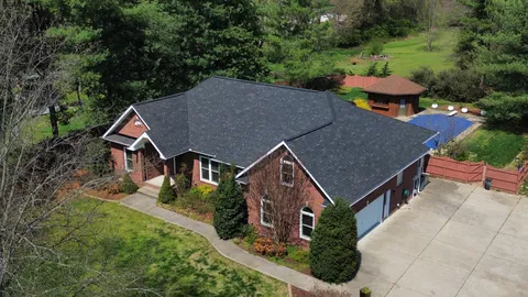 a view of pool with lawn chairs under an umbrella