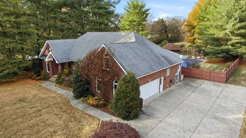 a aerial view of a house with a yard and large tree