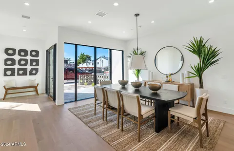a dining room with furniture window and wooden floor