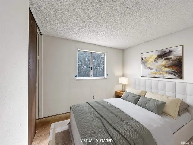 a bedroom with a bed and painting on the wall