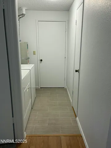 a view of a hallway with wooden floor and closet