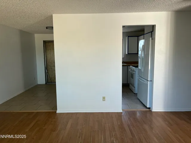 a view of empty room with wooden floor and a fireplace
