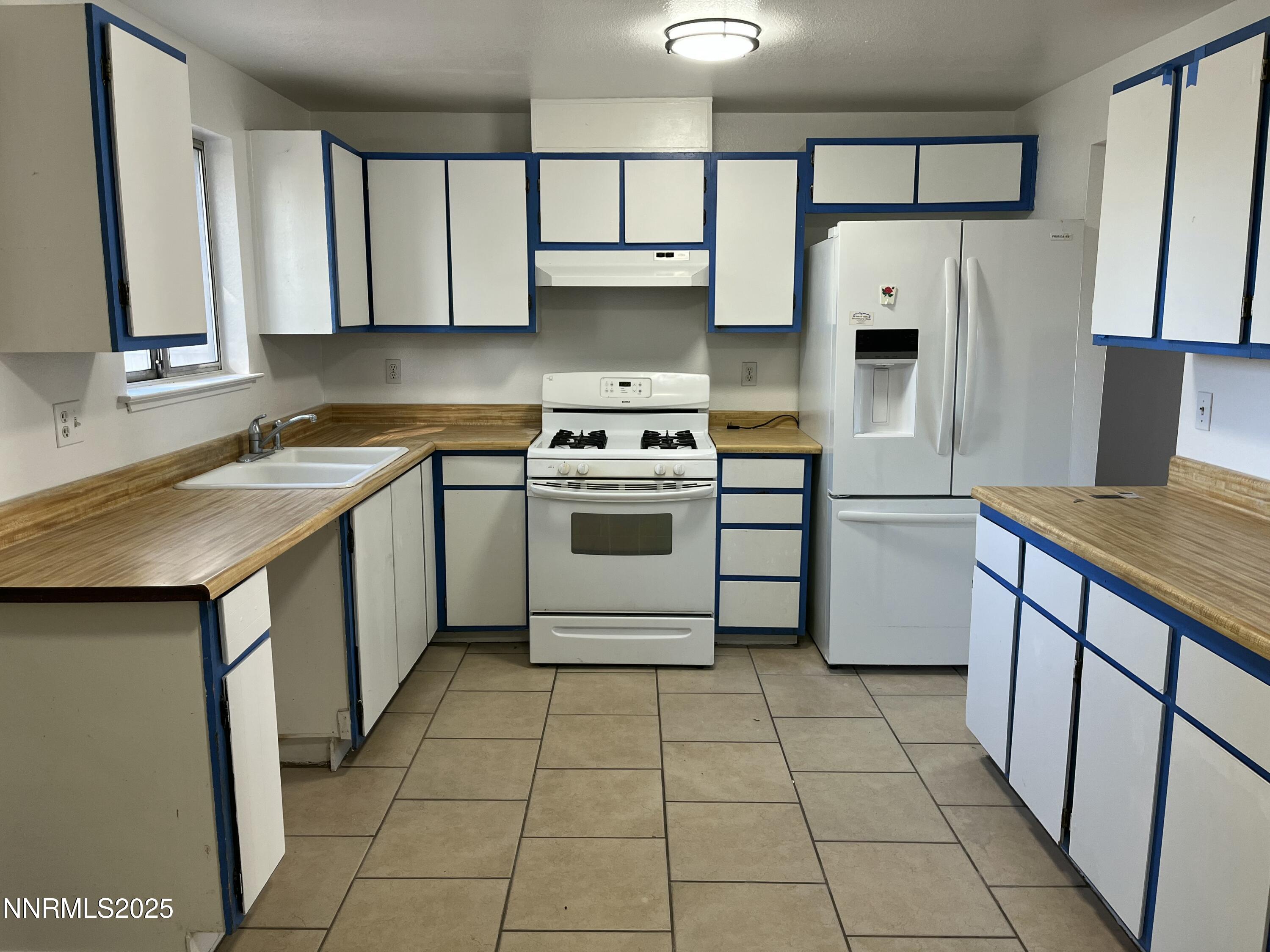 11019 Bornite Court Reno, NV 89506 - Photo 23 of 30 a kitchen with a stove a sink and a refrigerator