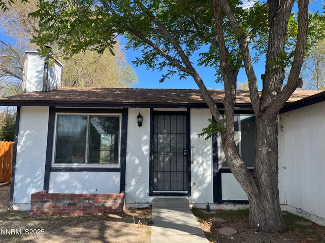 a view of a backyard with wooden fence and a large tree