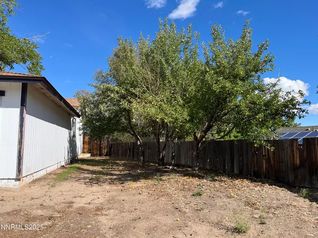 a front view of a house with a tree