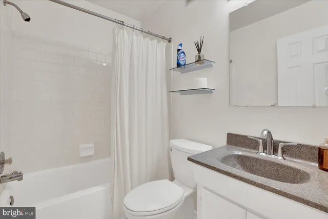 an empty room with windows and ceiling fan