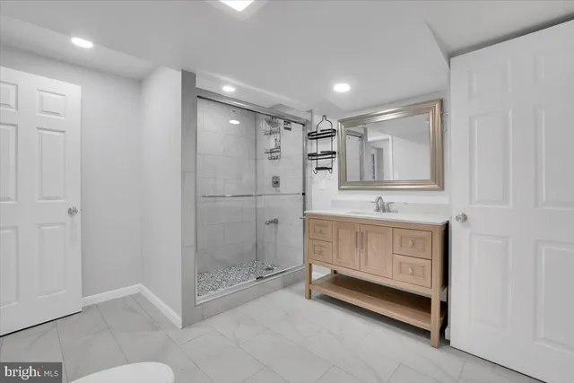 a bathroom with a shower sink and mirror