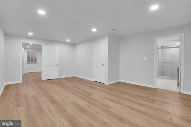 a view of empty room with wooden floor and windows