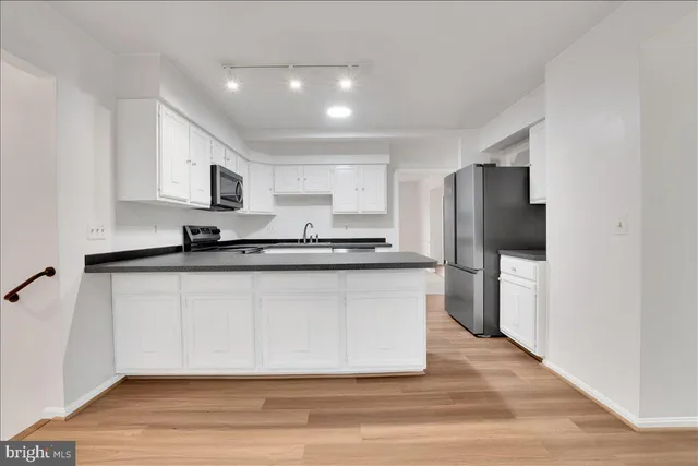 a kitchen with stainless steel appliances a refrigerator a stove a sink and a microwave