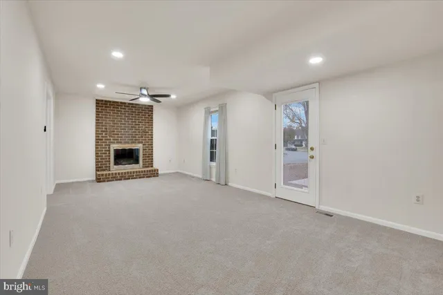 an empty room with fireplace and a window