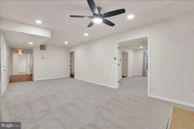 an empty room with fan and windows