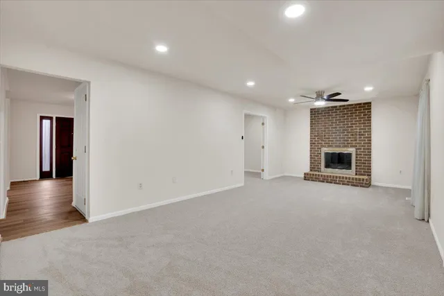 an empty room with wooden floor fireplace and cabinet