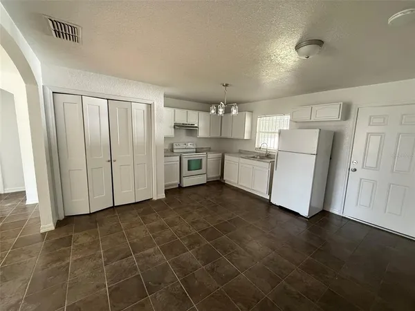 a kitchen with cabinets and wooden floor