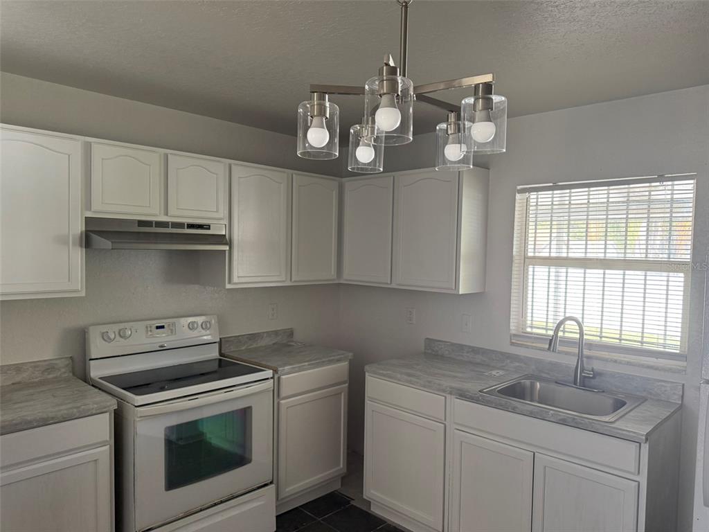 417 Francisco Way Kissimmee, FL 34758 - Photo 9 of 20 a kitchen with stainless steel appliances granite countertop a sink a stove and cabinets