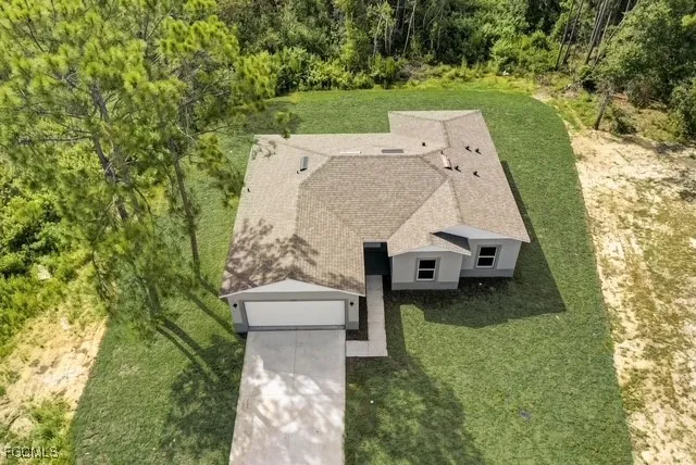 an aerial view of a house with a garden and trees