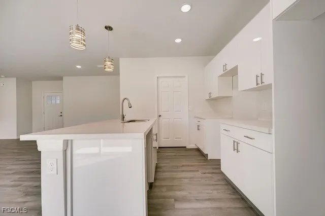 a kitchen with cabinets and wooden floor