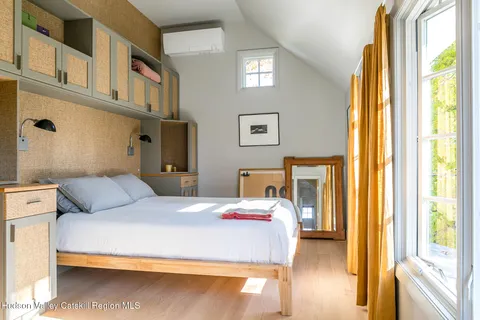 a bedroom with a large bed and a flat tv screen on dresser
