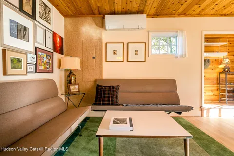 a black leather couch in a living room next to a window