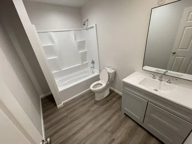 a bathroom with a sink a toilet a mirror and shower