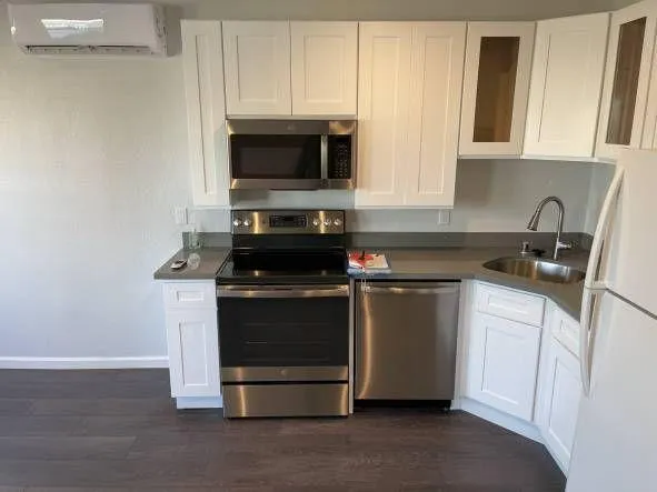 a kitchen with stainless steel appliances a stove a microwave a sink and cabinets