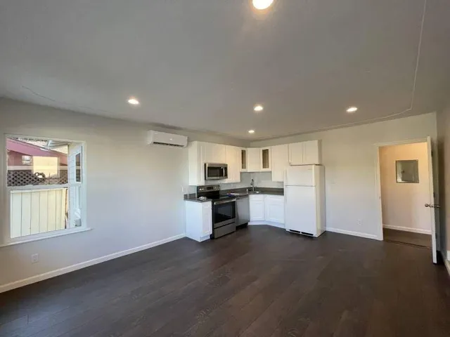 a kitchen with a refrigerator and a stove top oven