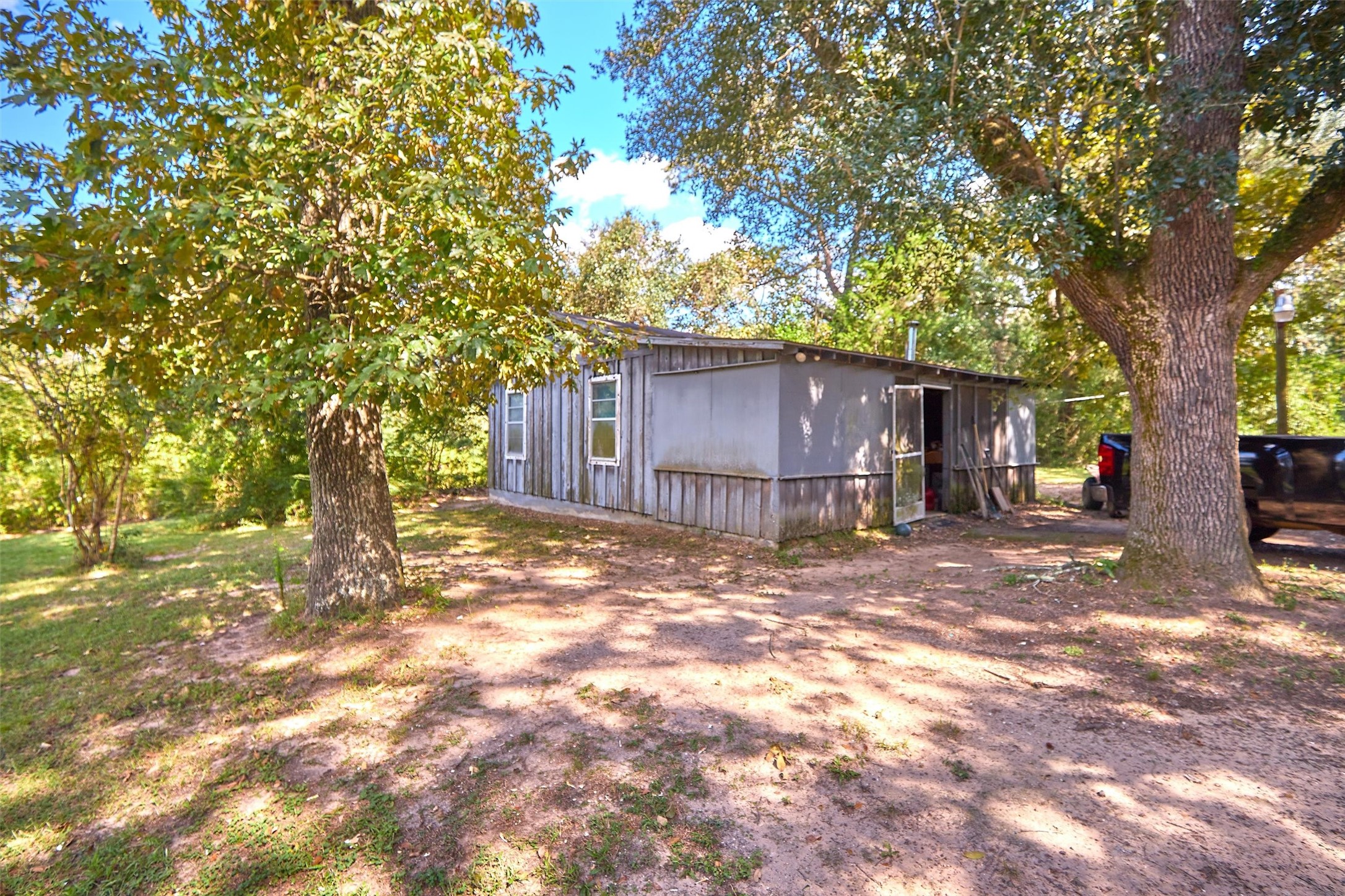 24030 Hegar Road Hockley, TX 77447 - Photo 15 of 40 Tucked beneath the shade of mature oak trees, the property features a cozy cabin that’s perfect for weekend getaways, a hunting retreat, or temporary living while you build your dream home. Simple yet functional, it provides shelter.